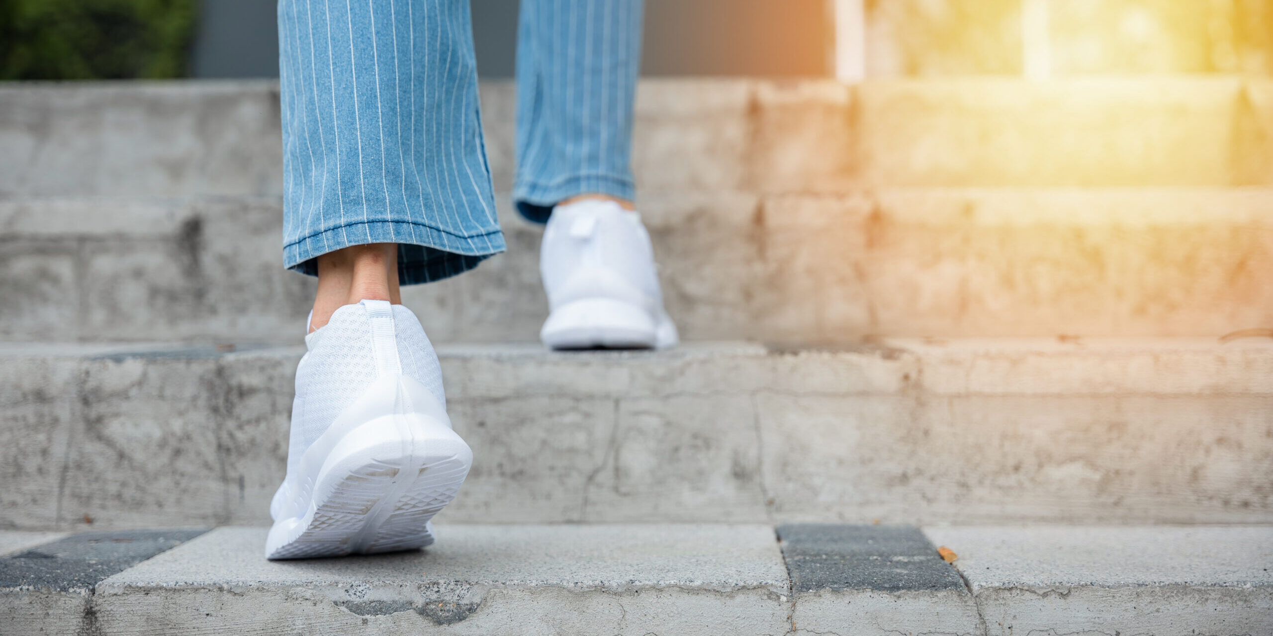 With sneakers on, a woman takes on the city stairway, showcasing her determination and progress. Each step is a reflection of her unwavering journey towards success and personal growth. step up